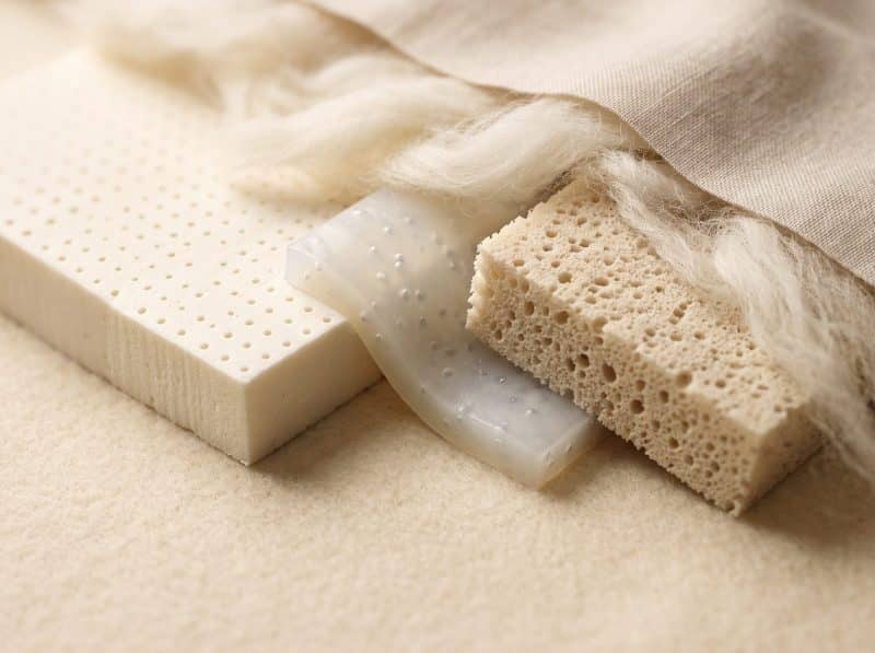 Close-up van latex, schuim en wol als matrasmaterialen op een beige stof